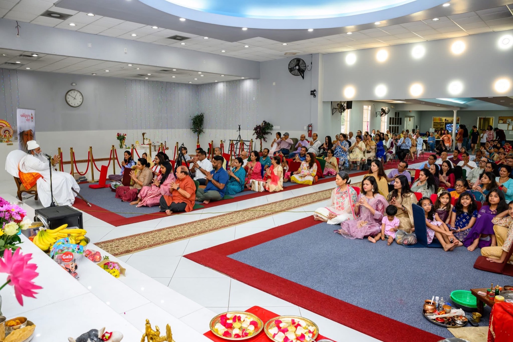 Saddguru Shri Dayal leading satsang with families gathered to listen
